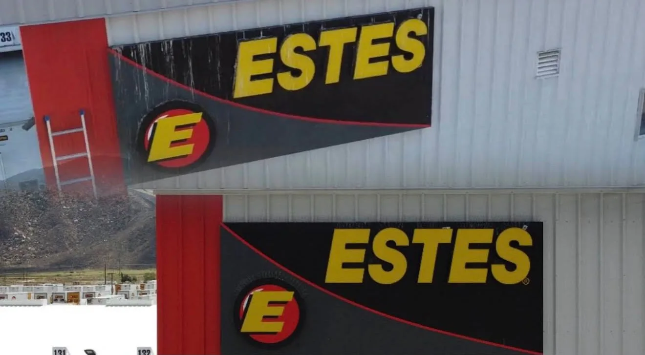 Exterior wall with large Estes banners featuring yellow ESTES text and red E logo on a black background.